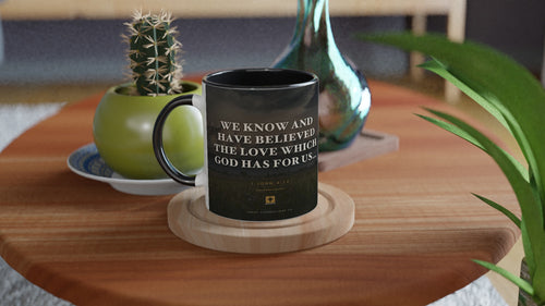 Black-handle 1 John 4:16 mug, dusk field photo design, styled with a cactus and vase