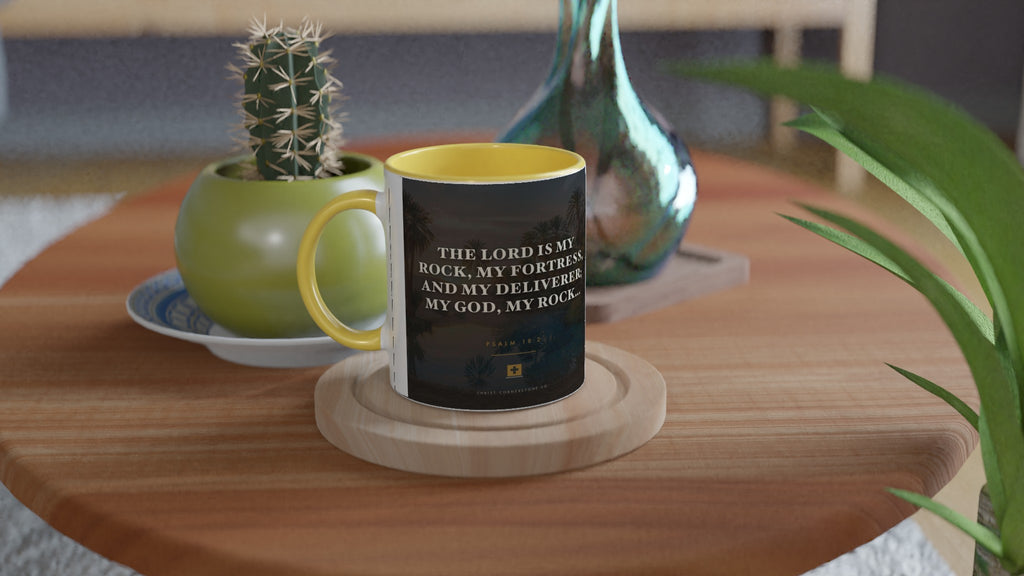 Psalm 18:2 ceramic mug with a yellow interior and handle, on a side table with a cactus