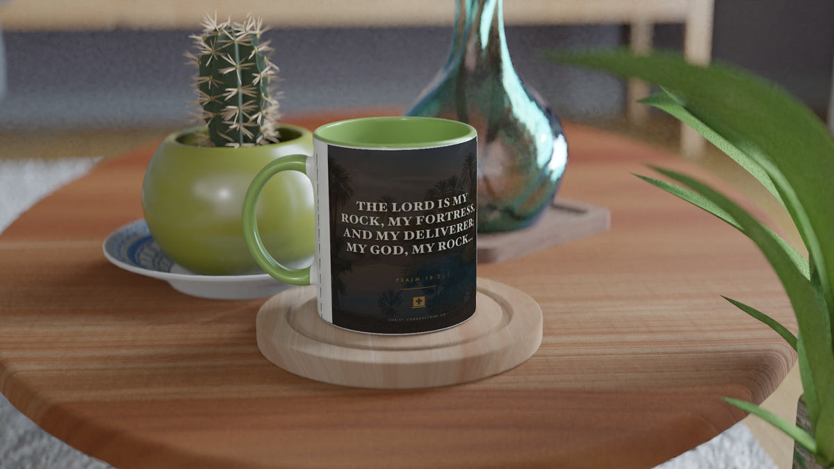 Psalm 18:2 ceramic mug with a green interior and handle, on a side table with a cactus