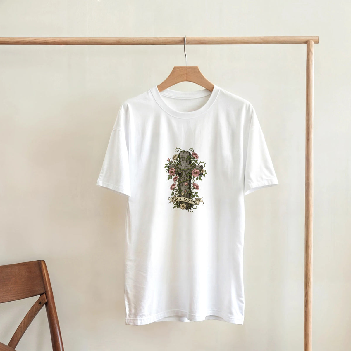White Faith Endures Adult Tee, hanging on a wooden rack, room mockup