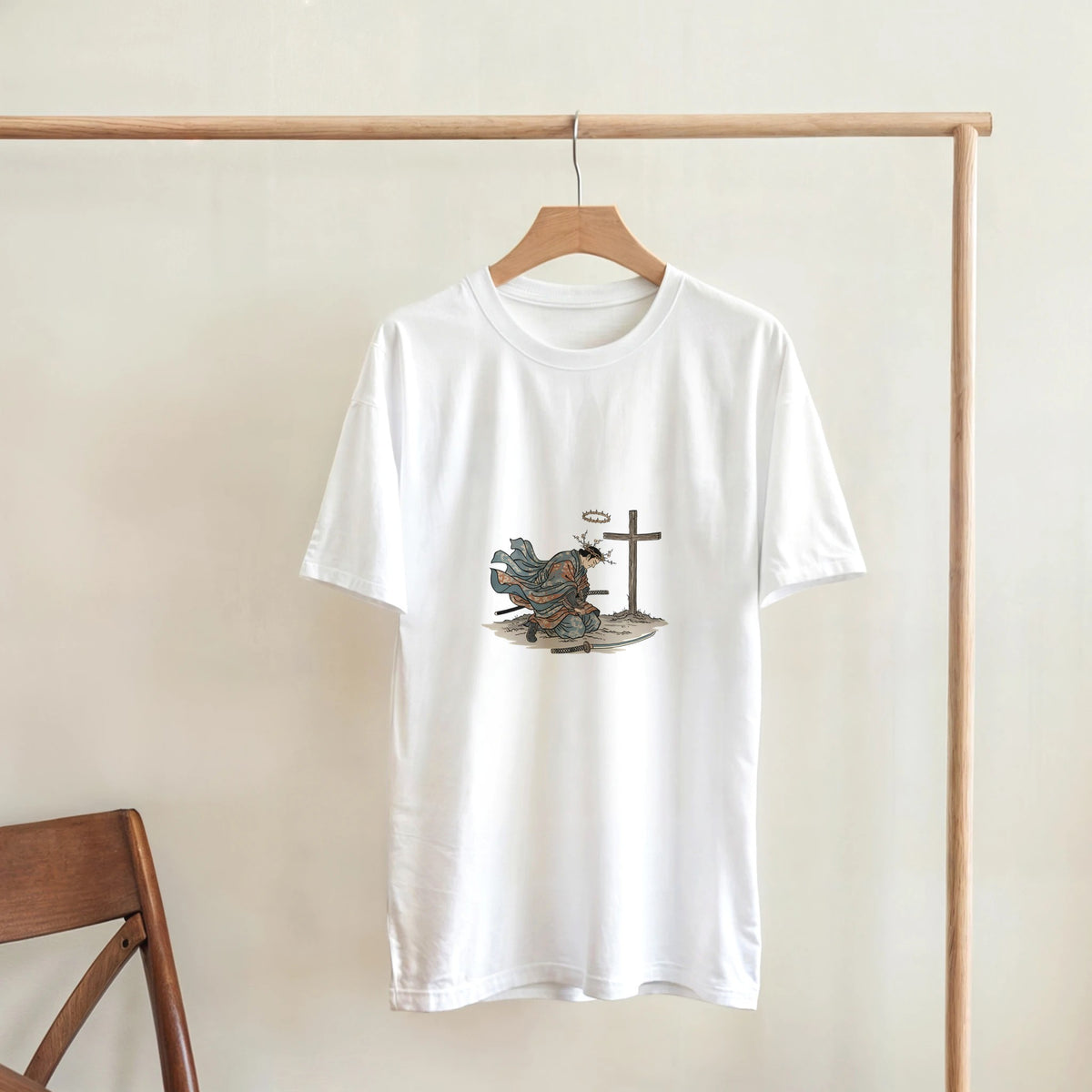 White The Wind And The Cross Adult Tee, hanging on a wooden rack, room mockup