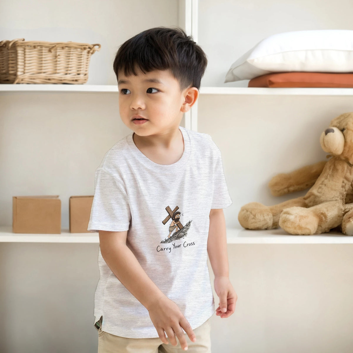 Grey Carry Your Cross Kids Tee, room mockup with a shelf and teddy bear