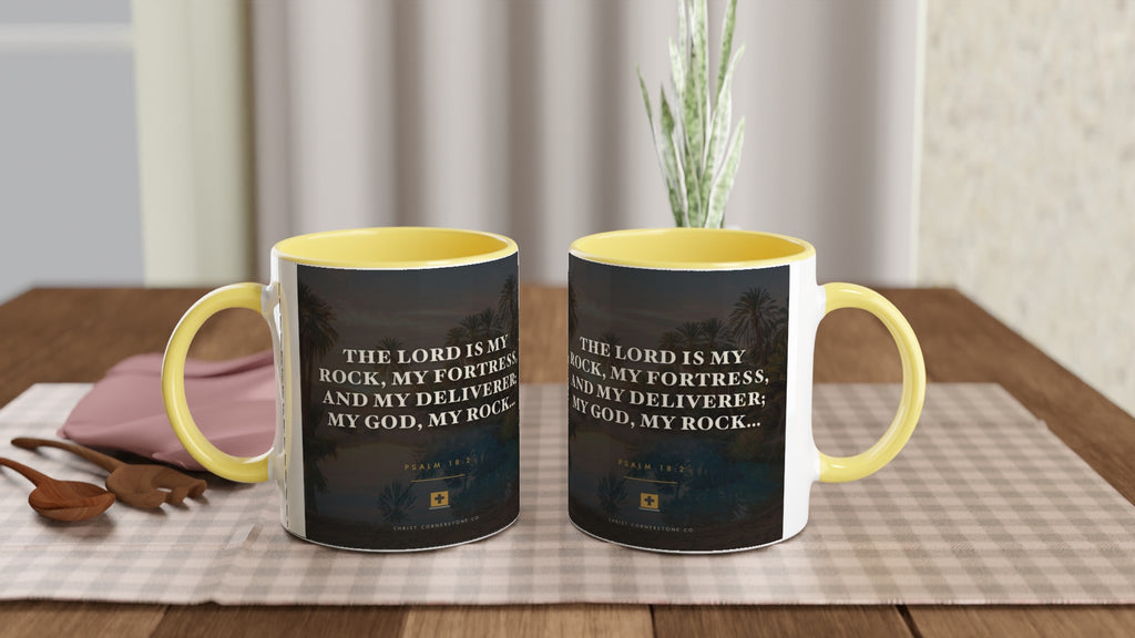 Two Psalm 18:2 ceramic mugs with yellow interiors, side by side on a table setting